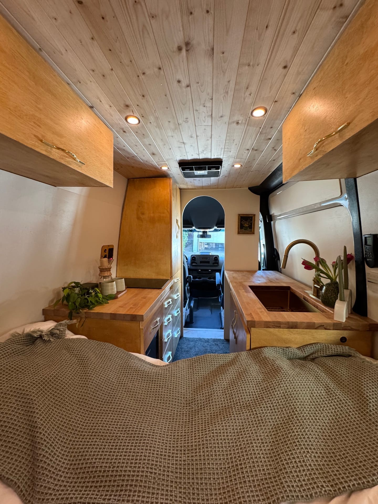 Anchor Sprinter van kitchen — birch cabinetry, brass faucet, round mirror