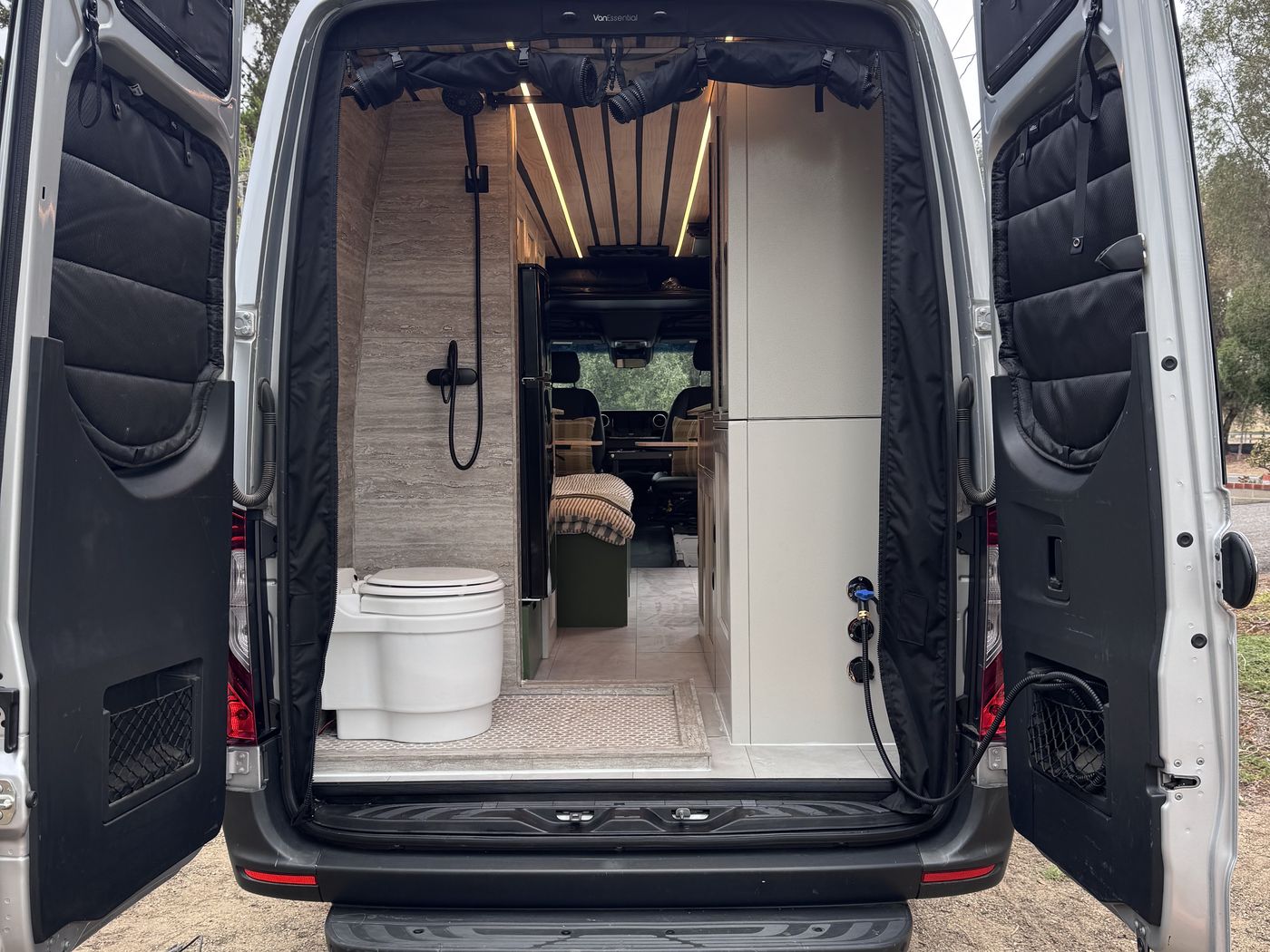 Grove Sprinter rear doors open showing the full width tiled wet bath and handheld shower