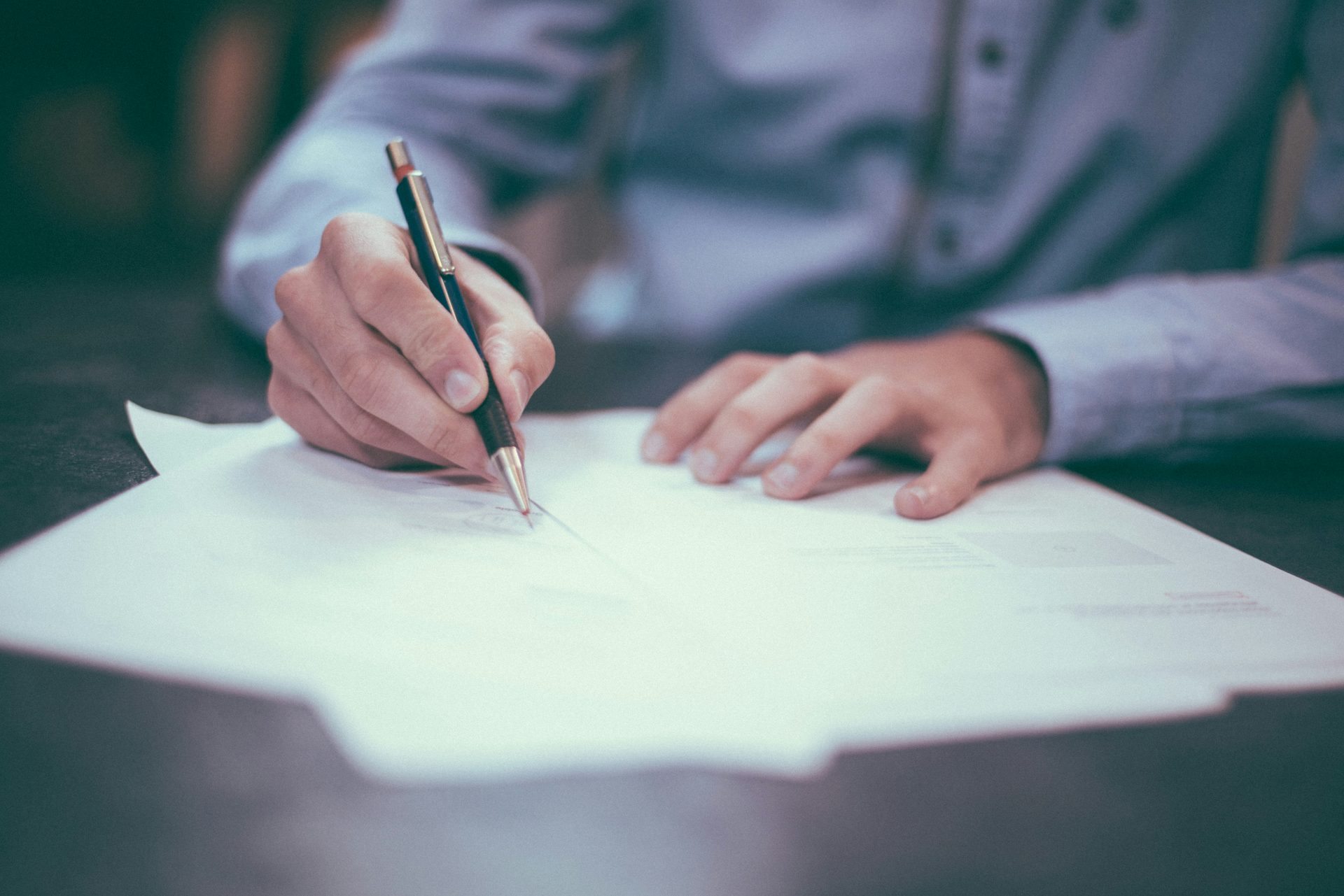 Signing an insurance document with pen