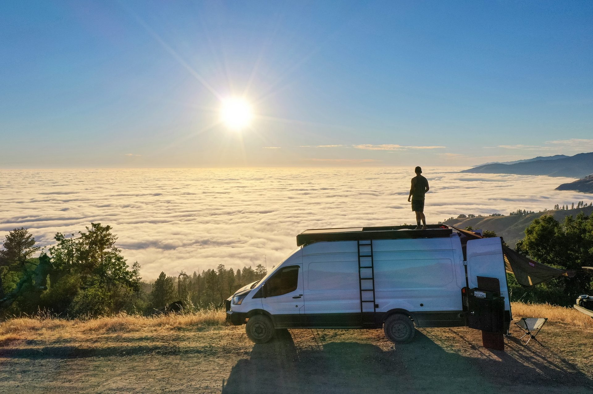 Sprinter van above the clouds at sunset with rooftop rack