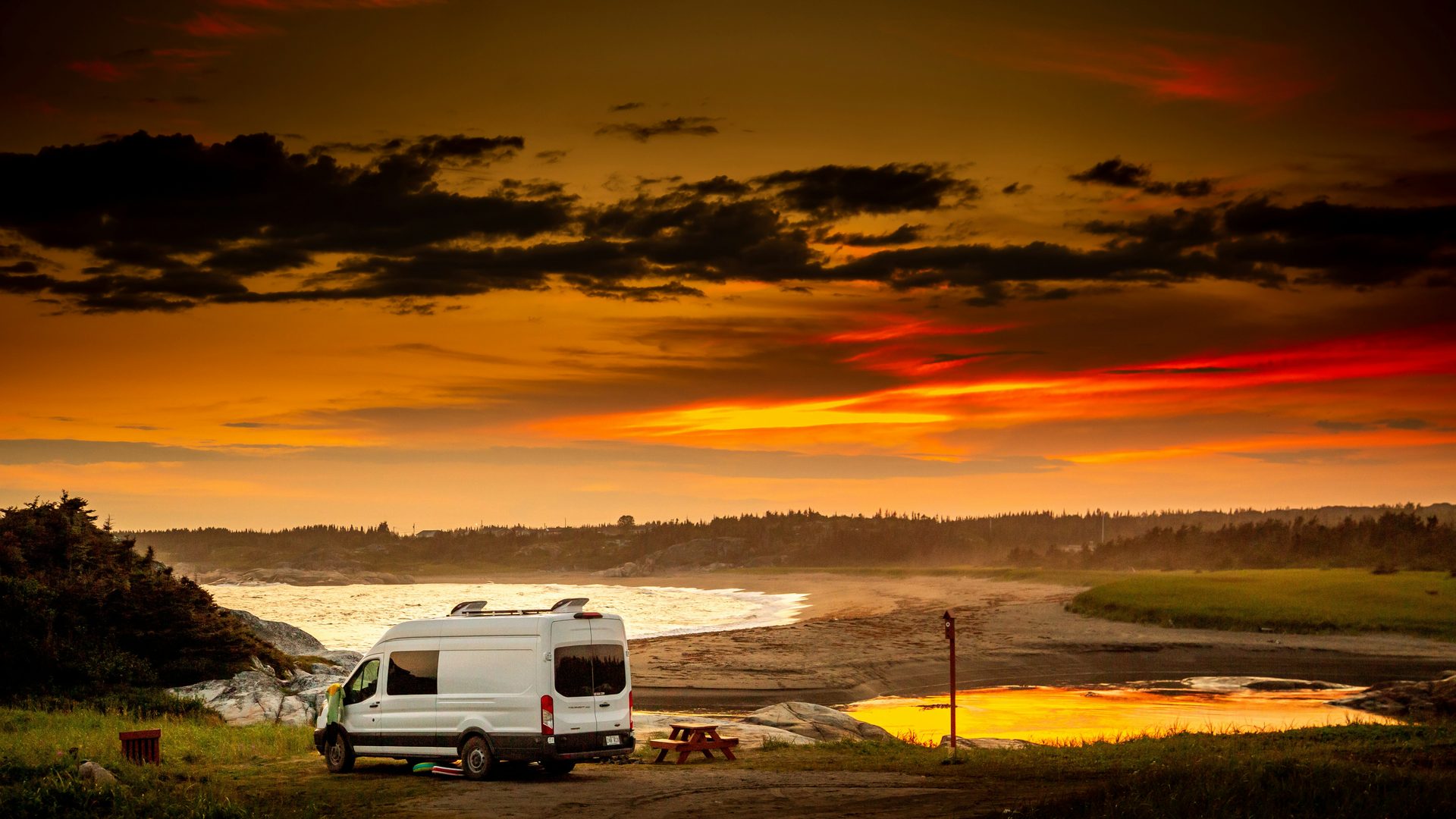 Ford Transit van at a sunset beach campsite