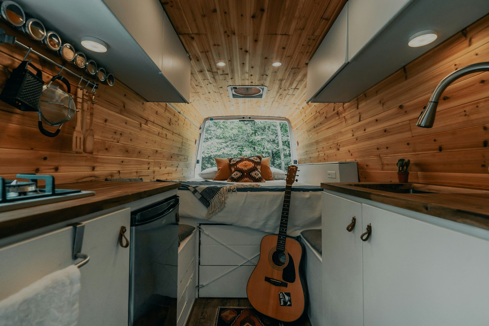 Custom van conversion interior with cedar kitchen and bed