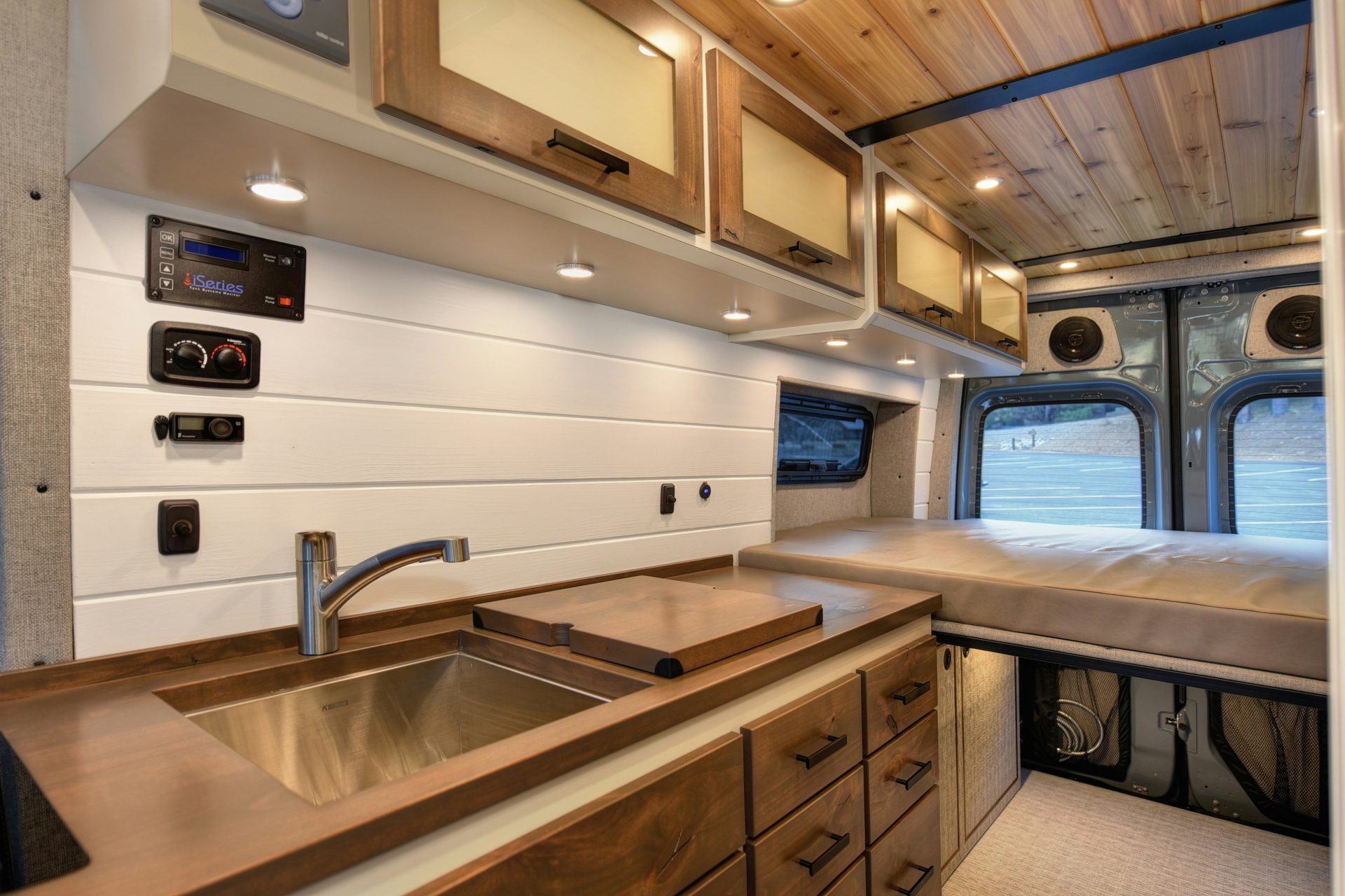 Van conversion kitchen with walnut counters and electrical panel